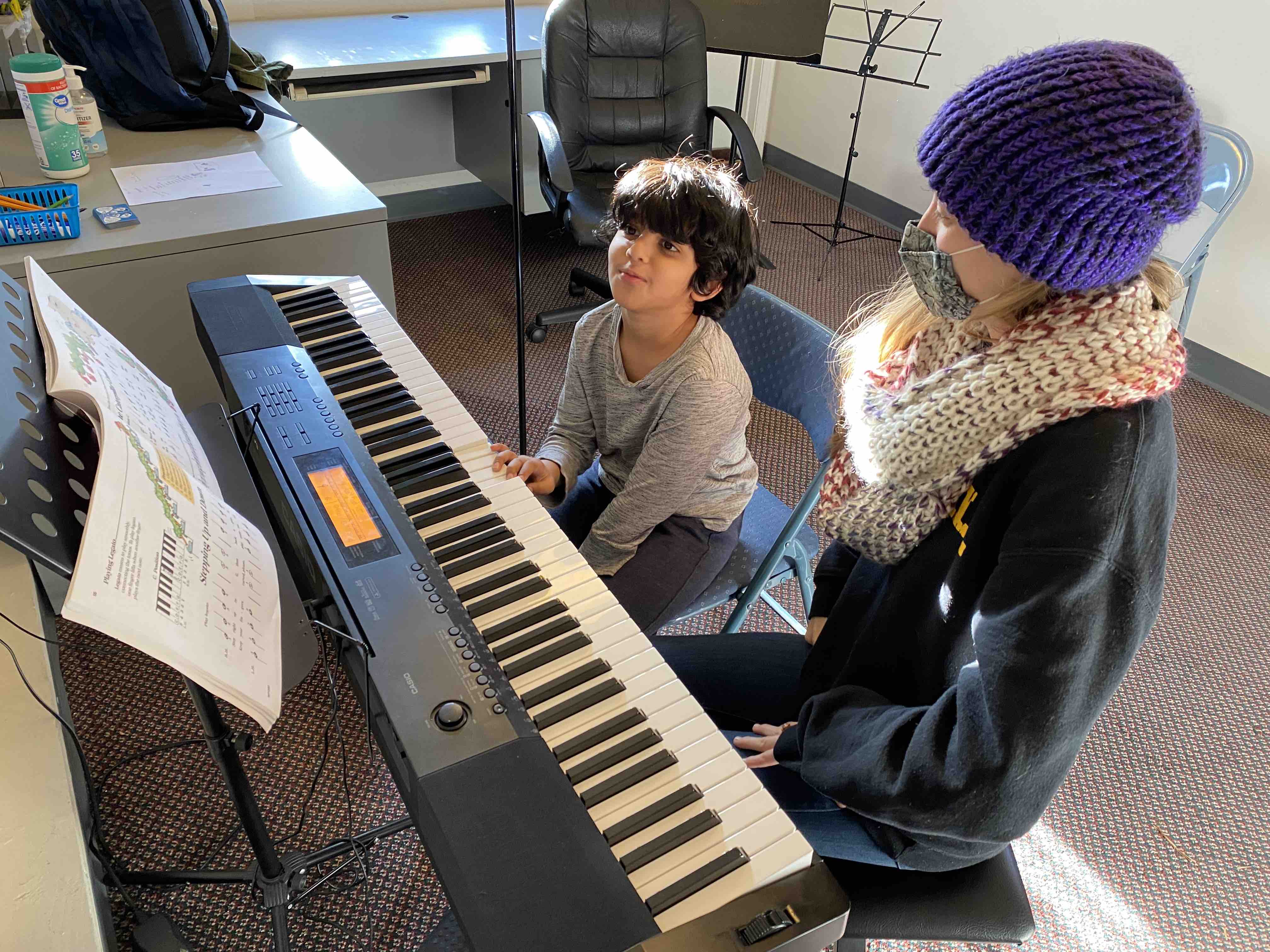 Teacher and young student learning piano
